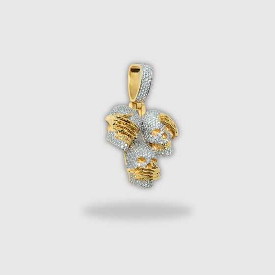 14k gold pendant with three skulls representing hear no evil, see no evil, speak no evil, showcasing exquisite craftsmanship.