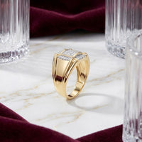 A breathtaking 10K Yellow Gold Diamond Cluster Ring 1/4CT, adorned with shimmering square-cut diamonds, rests on a white marble surface amid clear glass tumblers and rich burgundy velvet fabric.