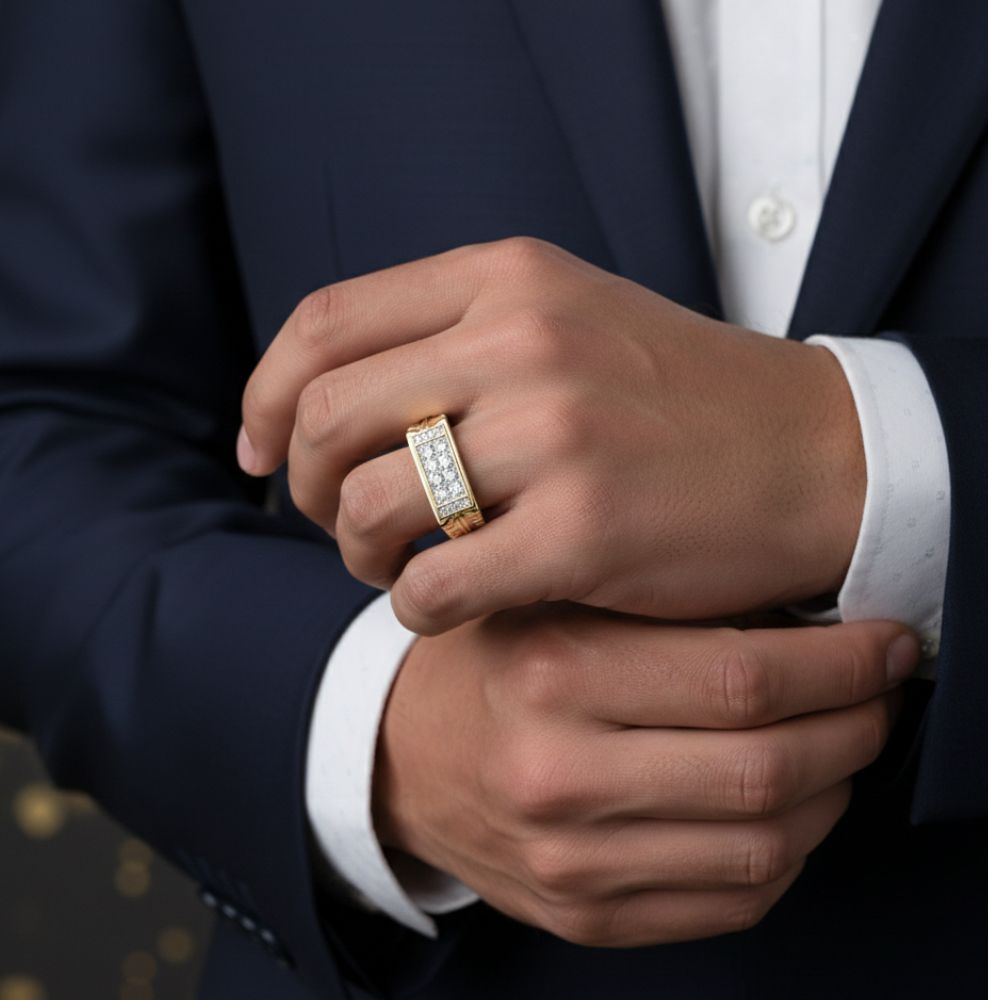 Wearing a dark suit, a person adjusts their hand to show off the 10k Gold Round Diamond Band Ring 1/2 Cttw, featuring a rectangular section of sparkling diamonds. The dark background is accented with soft golden bokeh lights.