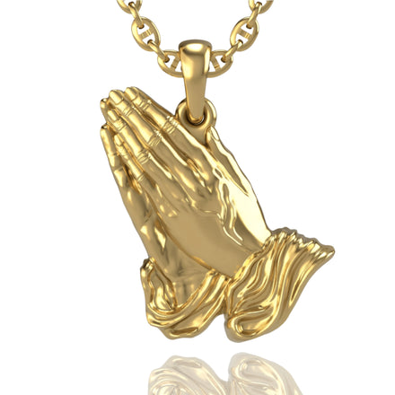 The 14k Gold Praying Hands Pendant features two detailed hands in prayer with flowing sleeves, hanging from a matching gold chain—a meaningful and elegant accessory.