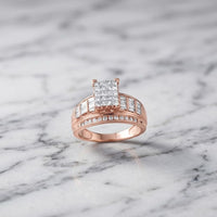 The 10k Gold Princess Diamond Bridal Engagement Ring 1 Cttw features a stunning princess diamond cluster with sparkling diamond accents on the band, beautifully displayed on a white marble surface.