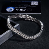 A close-up of the Double Row Moissanite Silver Bracelet - 3mm, crafted from 925 sterling silver with square-cut stones, displayed on a dark surface beside a black certification card.