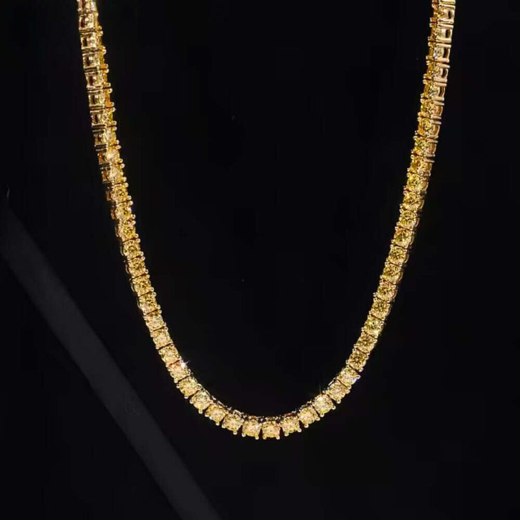 The Yellow Moissanite Tennis Chain - 3mm features square, closely set links with sparkling yellow moissanite gemstones, showcased against a solid black background.