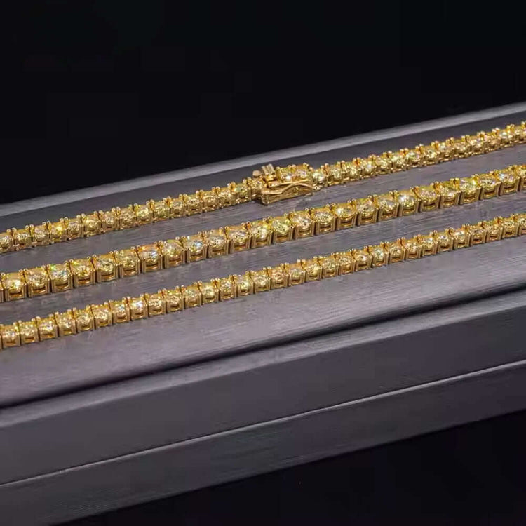 Two Yellow Moissanite Tennis Chain - 3mm bracelets are displayed on a dark rectangular jewelry box against a black background, showcasing rows of sparkling yellow moissanite gemstones.