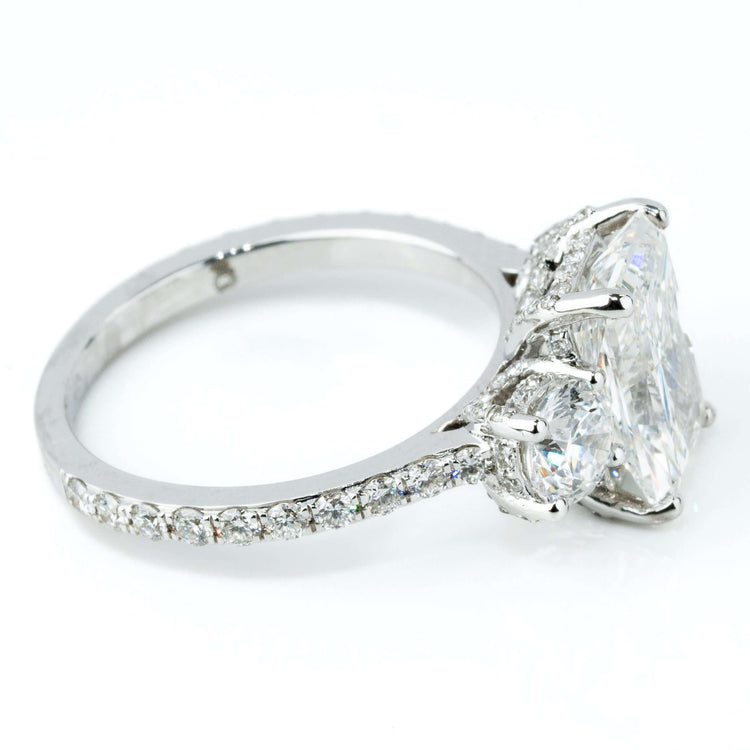 A close-up side view of the 4.84 CTW 14k White Gold Three Stone Radiant Engagement Ring, featuring a radiant-cut lab-grown center diamond, two smaller side diamonds, and accent diamonds set along the band.