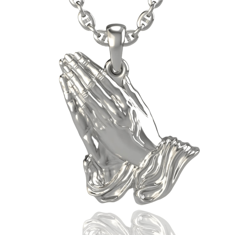 A timeless alternative to the classic 14k Gold Praying Hands Pendant, this silver pendant features two hands in prayer with polished, detailed fingers and cuffs that catch the light, hanging elegantly from a chain.