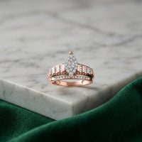 A 10k Gold Oval Diamond Cluster Bridal Ring (1/2 Cttw) rests on a white marble surface, with a green velvet cloth in the foreground.