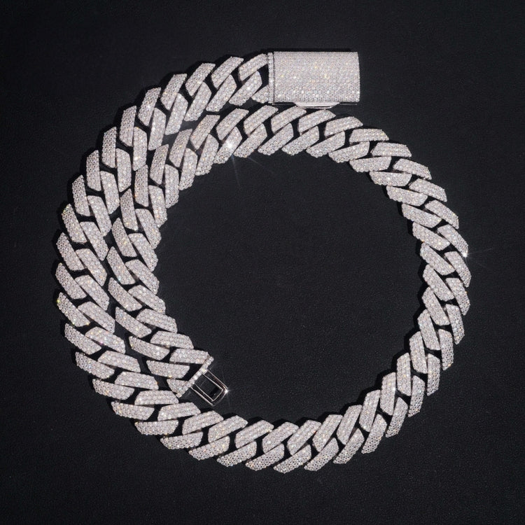 The Moissanite Cuban Links Chain 20mm - 925 Sterling Silver is displayed in a circle on a black background, highlighting its sparkling interlocking links and bold rectangular clasp.