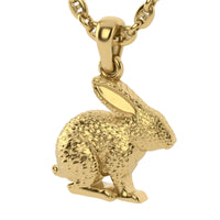 The 14k Gold Rabbit Pendant is a detailed gold charm shaped like a sitting rabbit with textured fur and large ears, hanging from an oval link chain—ideal for fans of nature-inspired jewelry.