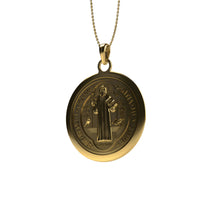 The 14k Gold Saint Benedict Pendant features an engraved robed figure, detailed text and symbols, a smooth circular outline, and comes with a fine chain.