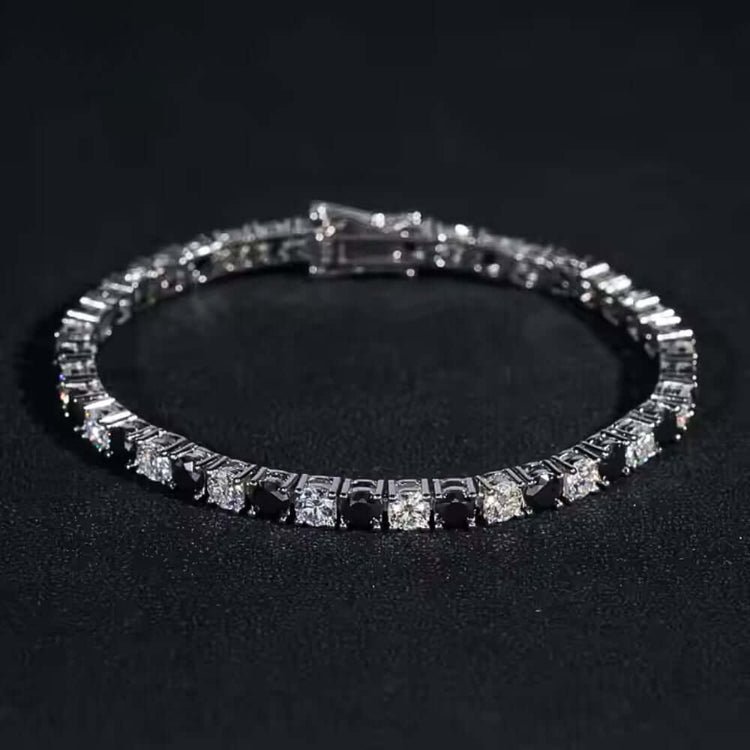 The Black Moissanite Tennis Bracelet - 4mm, made from 925 sterling silver, showcases alternating black and white square-cut gemstones, creating a bold and elegant look.