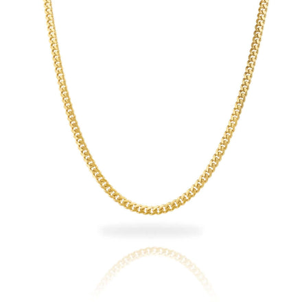 The Cuban Link Chain Solid Gold 4mm - Box Lock is featured against a white background. Its classic curb link design forms a smooth curve, with the gold chain and its reflection visible below.