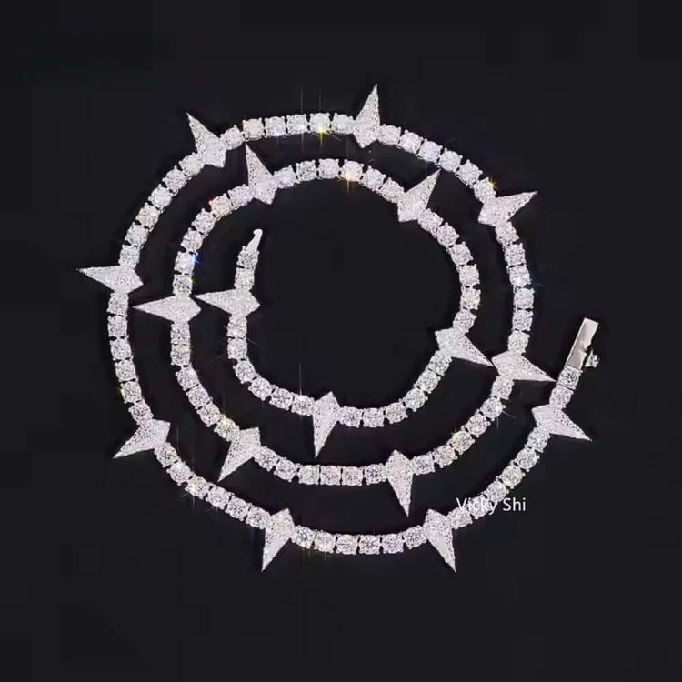 The Thorny Moissanite Tennis Chain - 4mm is displayed in a spiral on a black background, showcasing alternating square and star-shaped segments for a striking effect.