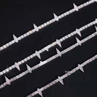 Four Thorny Moissanite Tennis Chains - 4mm are arranged diagonally on a black background. Each features round, diamond-like stones and pointed triangular spikes for a bold, thorny look.
