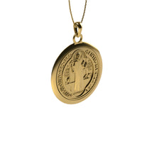 The 14k Gold Saint Benedict Pendant showcases an engraved saint surrounded by intricate inscriptions, suspended from a fine gold chain and displayed against a plain white background.