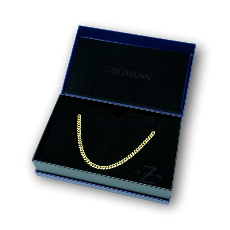 The Cuban Link Chain Solid Gold 5mm - Box Lock is shown in an open, dark box with GOLDZENN printed inside the lid and a black velvet-like lining.