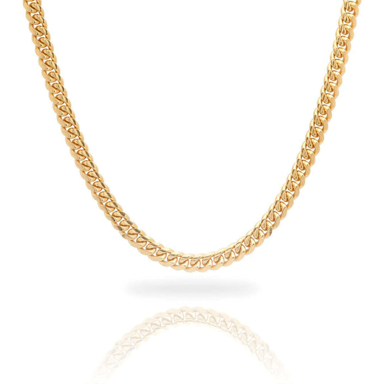 A close-up of the Cuban Link Chain Solid Gold 6mm - Box Lock, featuring a thick, intricate link design, displayed on a white background with a subtle reflection beneath.