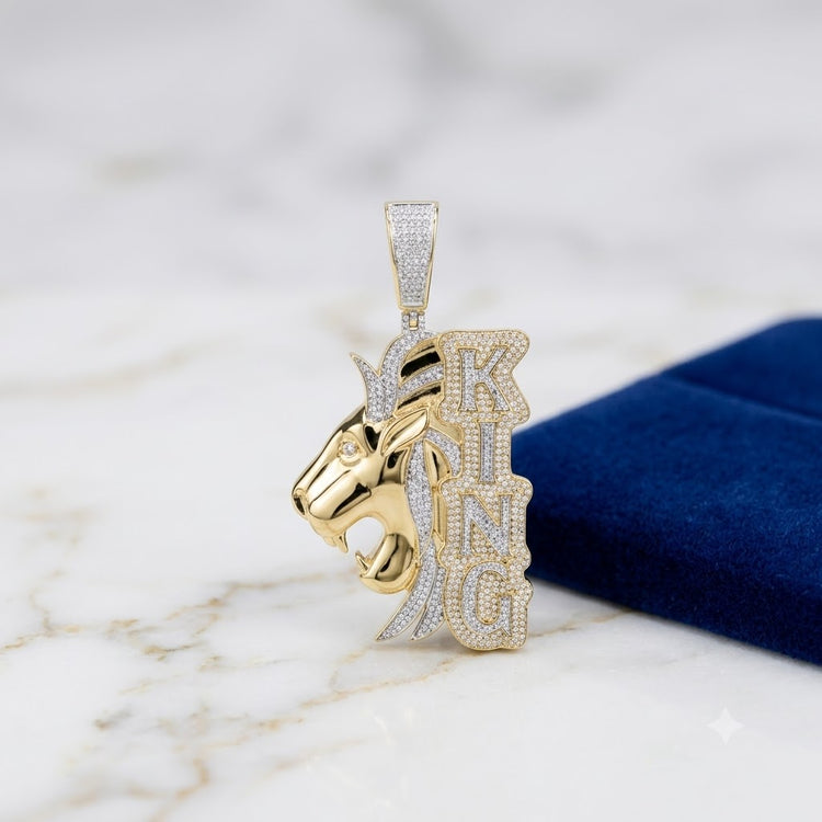 The 10K Gold Diamond Lion King Charm 2.2 CTW features a roaring lion's head and KING in diamond letters, shown on white marble beside a blue velvet box—a striking natural diamond jewelry piece for rulers.