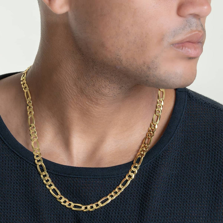 A person in a black textured shirt wears the Figaro Chain 8mm - 14k Gold Bonded, shown from neck to upper chest with their face partially visible and turned to the side.