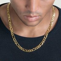 A close-up of a person wearing a black textured shirt and the Figaro Chain 8mm - 14k Gold Bonded. The men's gold chain rests on the neck below a smooth jawline and neutral expression.
