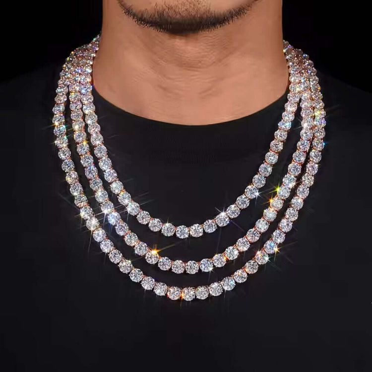 A person wearing a black shirt and three layered, sparkling diamond tennis chains—one of which is the eye-catching Rose Gold Plated Moissanite Tennis Chain (8mm)—around their neck.