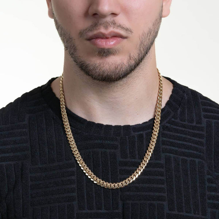 A man wearing a black textured shirt models the 8mm Handmade Miami Cuban Link Chain in solid gold (10K/14K/18K), shown from the shoulders up against a plain light background.