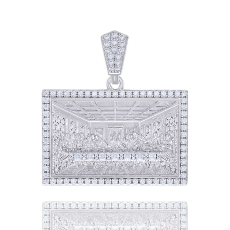 The Baguette Round Moissanite Last Supper is a rectangular sterling silver pendant featuring an engraved Last Supper scene and diamond accents, with a decorative bail for attaching to a necklace.