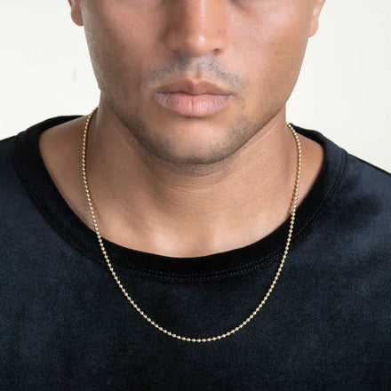 A person wears a black velvet shirt and a thin Beads Chains necklace, shown from the shoulders up with only the lower half of their face visible.