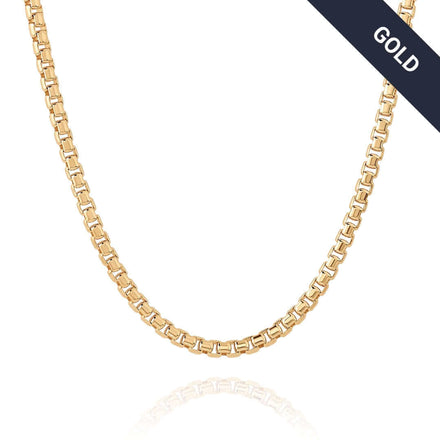 The Box Chain Yellow Gold - 2.5mm necklace, featuring a smooth, shiny finish, is shown on a white background with a diagonal black label in the top right corner displaying "GOLD" in white text.