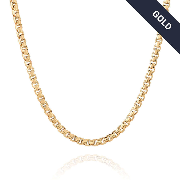 The Box Chain Yellow Gold - 2.5mm necklace, featuring a smooth, shiny finish, is shown on a white background with a diagonal black label in the top right corner displaying "GOLD" in white text.