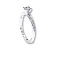 The Brilliance Eternity Lab Grown Diamond Engagement Ring showcases a round lab grown diamond center and accent stones along the band, crafted in white gold and photographed elegantly on a white background.