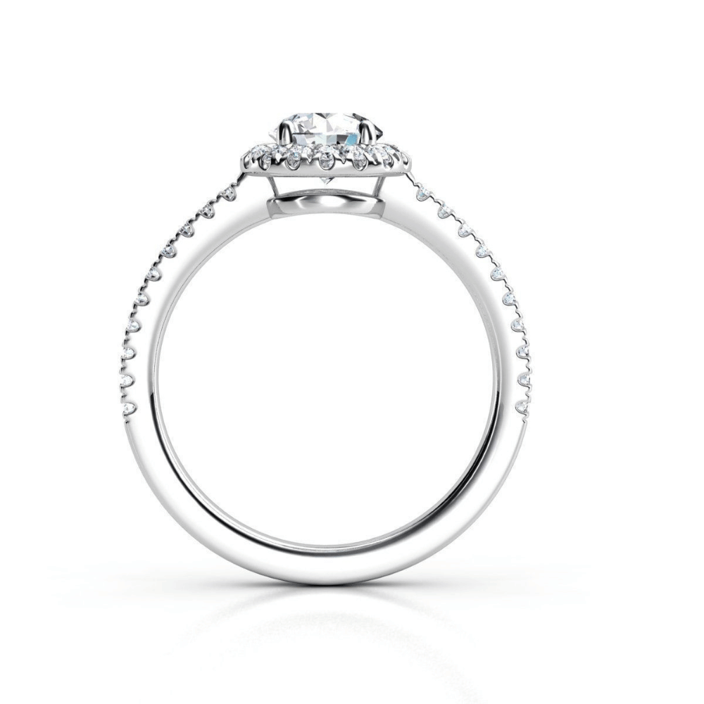The Brilliance Halo Diamond Ring features a radiant round center diamond with pavé-set accents on the band and beneath the center stone, shown in white gold or platinum from a side view.