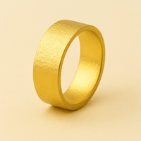 An 8mm Flat Band Ring - 24k with a matte finish stands upright on a light beige background, highlighting the timeless elegance of this wide gold band.