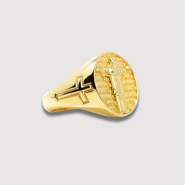 The Circular Jesus Ring - 14k Solid Yellow Gold features a black cross on the band and an engraved crucifix with surrounding text on the circular face, making it a bold men's gold ring.