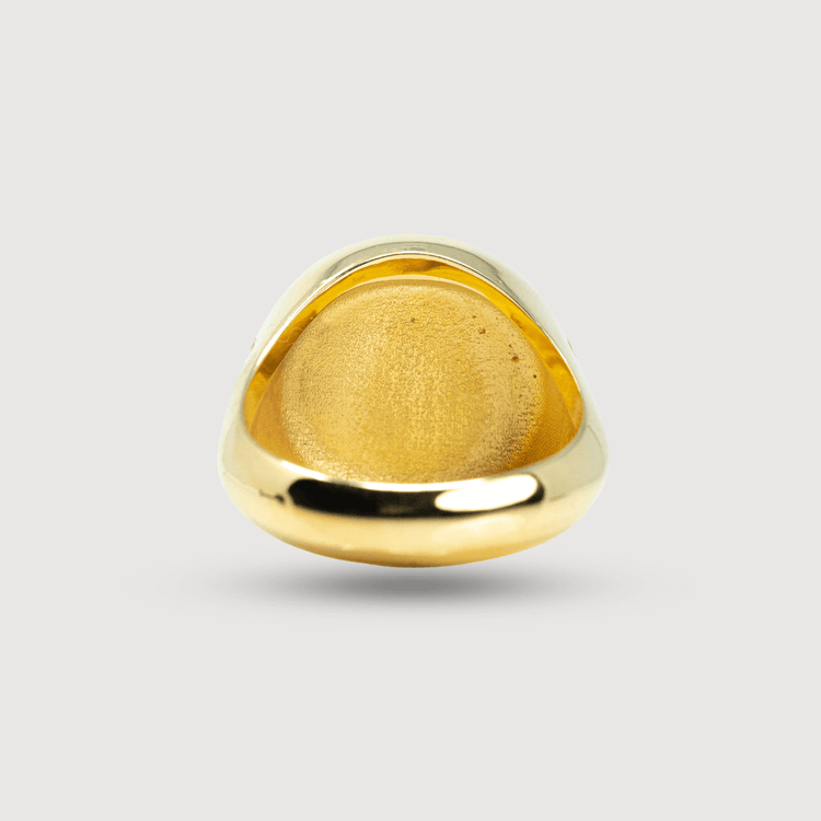 The Circular Jesus Ring in 14k solid yellow gold is shown from below, highlighting its smooth, polished inner surface and rounded edges against a light gray background.