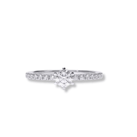 The Classic Solitaire Lab Diamond Ring with Dazzling Pavé Accents showcases a round brilliant lab diamond and sparkling pavé accents on the band—a refined women’s engagement ring, pictured on a white background.