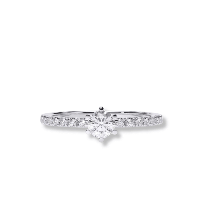 The Classic Solitaire Lab Diamond Ring with Dazzling Pavé Accents showcases a round brilliant lab diamond and sparkling pavé accents on the band—a refined women’s engagement ring, pictured on a white background.
