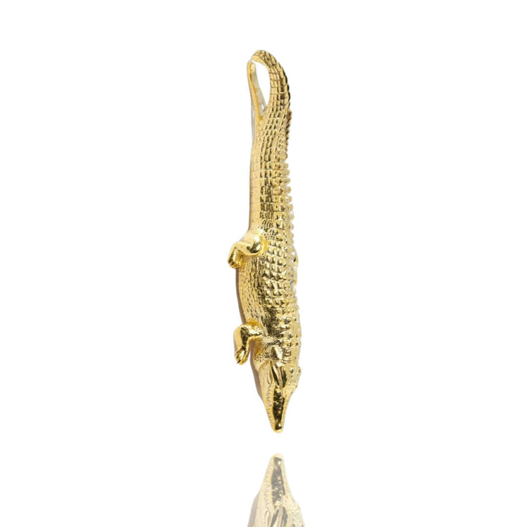 A Crocodile Pendant - 14k Solid Yellow Gold is displayed against a white background, with its reflection visible below.