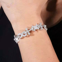 A close-up of a wrist adorned with the Cross Infinity Link Moissanite Bracelet, featuring sparkling moissanite stones in elegant links. The dark background accentuates the bracelet's brilliance.