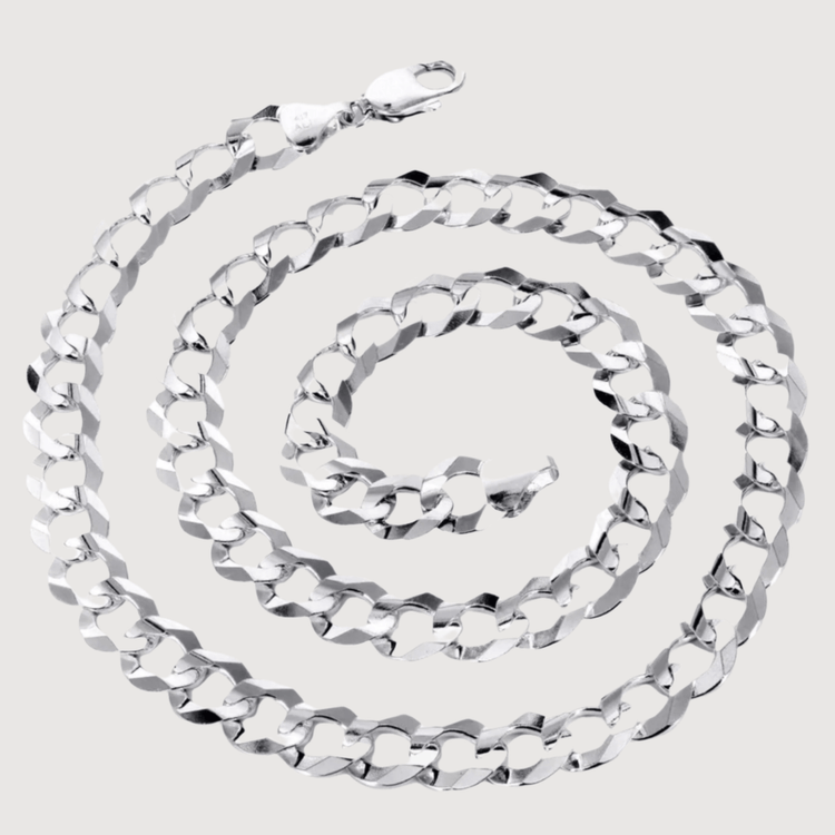 A Curb Link Chain - 2mm-5mm Solid White Gold is coiled in a spiral on a plain light gray background, highlighting its shiny flat interlocking links.