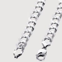 Close-up of the Curb Link Chain - 6mm-9.5mm Solid White Gold, featuring shiny, large interlocking curb links and a lobster clasp, set against a plain light background.