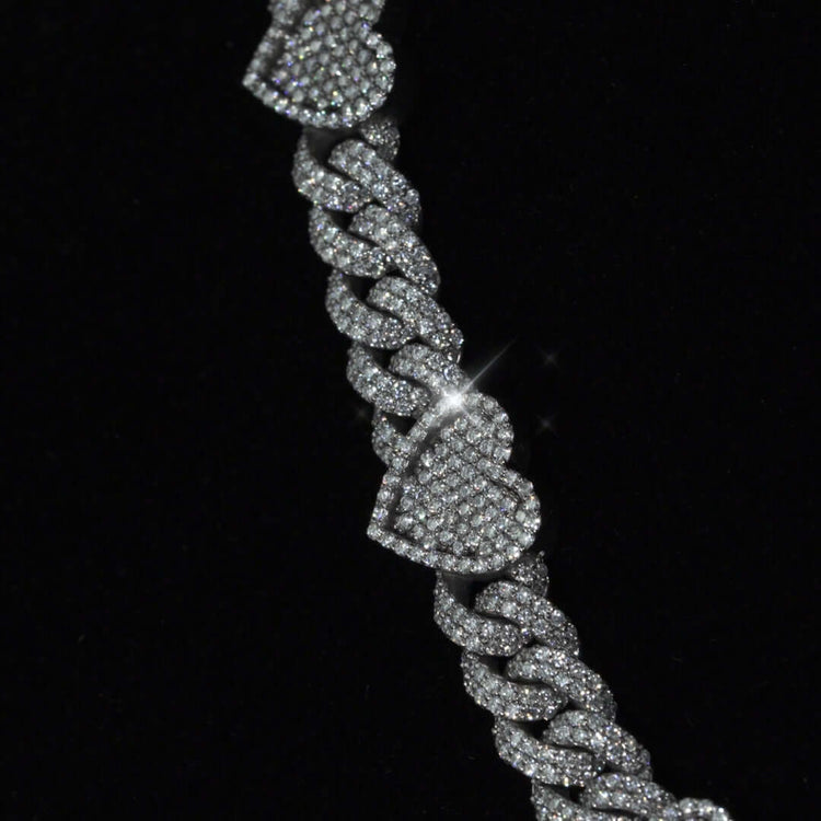 A close-up of the Diamond Chain - Heart Shaped 10k White Gold bracelet, featuring heart-shaped links encrusted with natural diamonds, set against a black background.