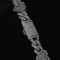 A close-up of the Diamond Chain - Heart Shaped 10k White Gold bracelet, featuring heart-shaped links adorned with sparkling natural diamonds, set against a black background.