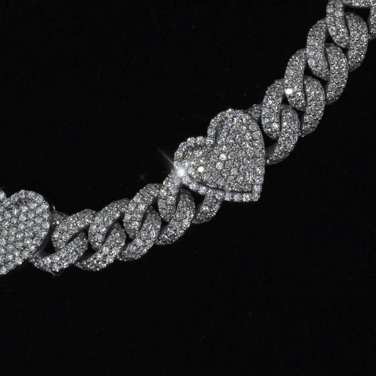 A close-up of the Diamond Chain - Heart Shaped 10k White Gold, highlighting its large heart-shaped links adorned with natural diamonds, set against a black background.