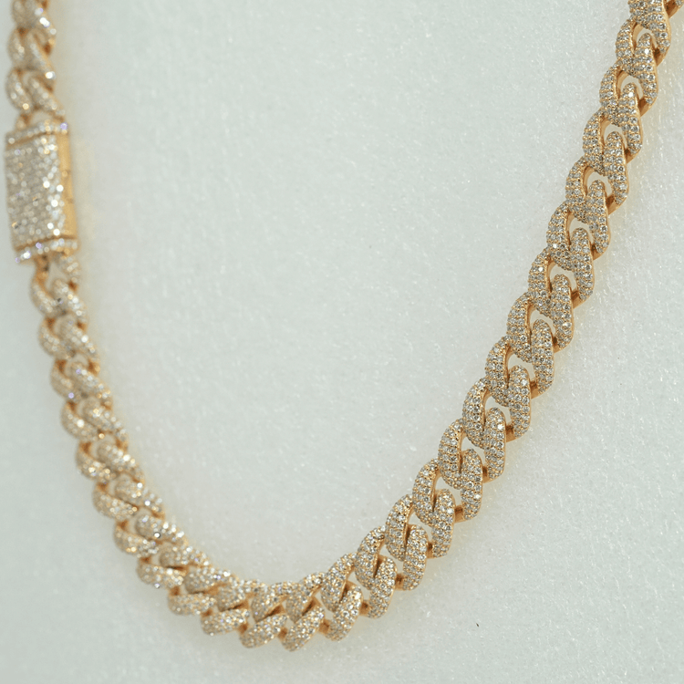 The Diamond Cuban Link Chain – 11mm is crafted in 10k solid gold, featuring a textured, lab-grown diamond-encrusted design, shown against a light neutral background.