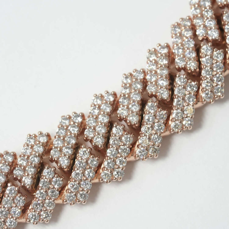 A close-up of a rose gold bracelet with rows of sparkling round-cut diamonds in a zigzag pattern, elegantly paired with the Diamond Cuban Link Chain - 15mm, displayed on a light background.