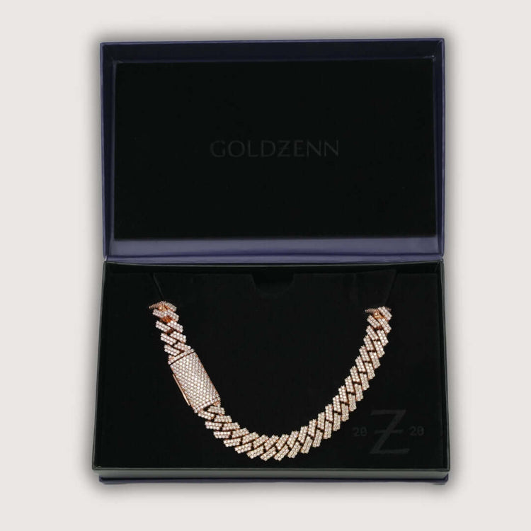 The Diamond Cuban Link Chain - 15mm, featuring an intricate gold and diamond woven design, is displayed in an open black box labeled GOLDZENN inside the lid.
