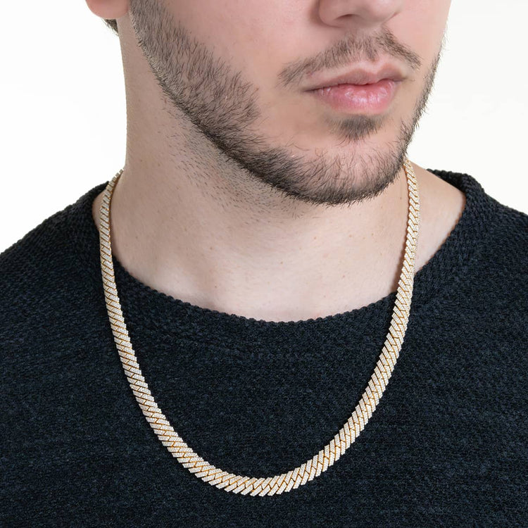 A man with a short beard wears a textured black sweater and the Diamond Cuban Link Chain Prong - Solid Yellow Gold. The image is cropped at the nose and above the chest, drawing focus to this striking necklace.