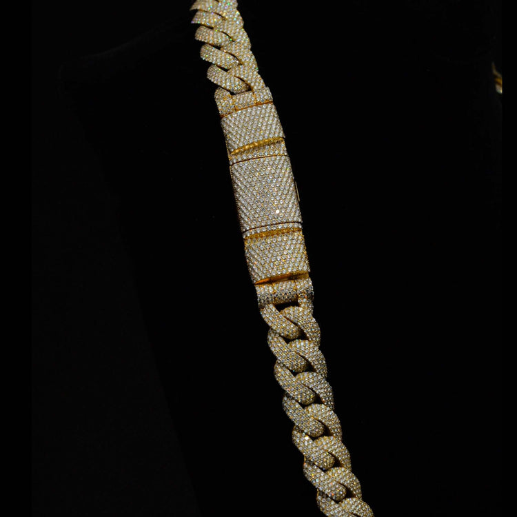 A close-up of the Diamond Cuban Link Chain - Semi Solid - 16mm, crafted in 10k gold and encrusted with small lab-grown diamonds, displayed against a black background.