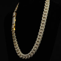 The Diamond Cuban Link Chain - Semi Solid - 16mm features 10k gold, shimmering lab-grown diamond accents, and a bold rectangular clasp, elegantly displayed on black velvet.